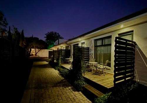 a patio with a table and chairs next to a building at Blix Inn Guesthouse in Stellenbosch
