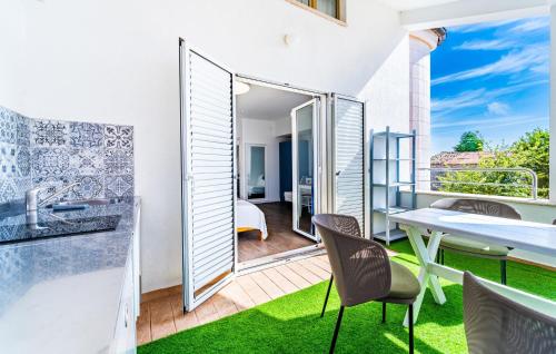 a room with a balcony with a table and chairs at Cozy Apartment In Fazana With Wifi in Fažana