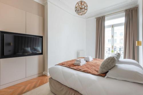 une chambre avec un grand lit et une télévision à écran plat dans l'établissement Elegant apartment - 2BR-4P - Arc de Triomphe, à Paris