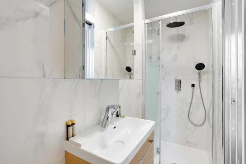 une salle de bain blanche avec un lavabo et une douche dans l'établissement Elegant studio - 2P - Chaillot, à Paris