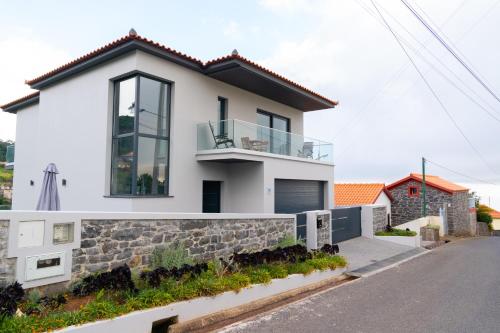 une maison blanche avec un mur en pierre dans l'établissement Paradise views - Pereira House, à Arco da Calheta