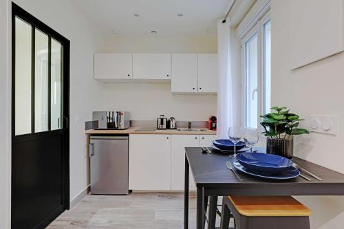 d'une cuisine avec une table et des plaques bleues. dans l'établissement Magnificent studio - 2P - Levallois-Perret, à Levallois-Perret