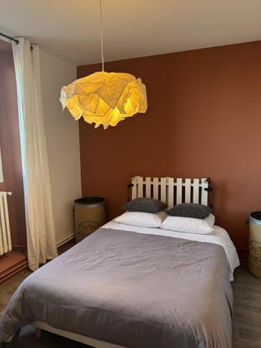 - une chambre avec un grand lit et une lumière jaune dans l'établissement Maison Bacou N2, à Carcassonne
