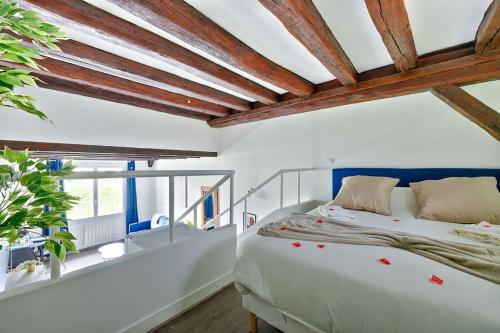a bedroom with a bed and a wooden ceiling at Welcome to Clara House in Wissous