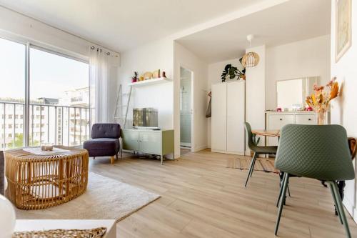 un salon avec une table et des chaises et une cuisine dans l'établissement Studio 119, à Levallois-Perret