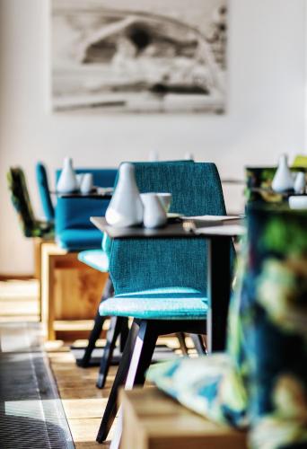 a table with blue chairs in a room at Seehotel Litz in Langenargen