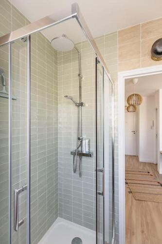 une salle de bain avec une douche avec une porte vitrée dans l'établissement Studio 119, à Levallois-Perret