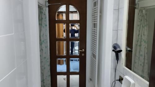 a hallway with a wooden door and a mirror at La Vecchia Posta in Anzano del Parco