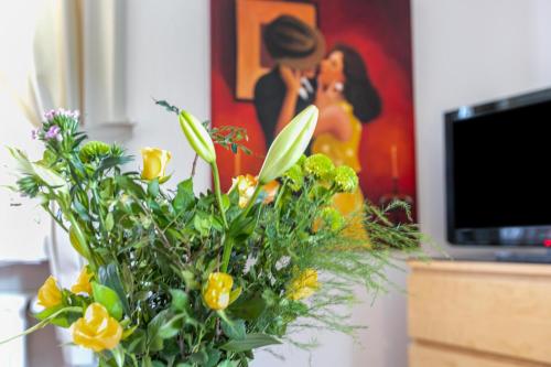 a vase filled with yellow flowers in front of a painting at Atlanta Pur in Pellworm