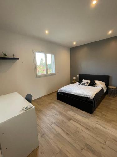 une chambre avec un lit et un parquet dans l'établissement Maison lumineuse à Porto-Vecchio, à Porto-Vecchio