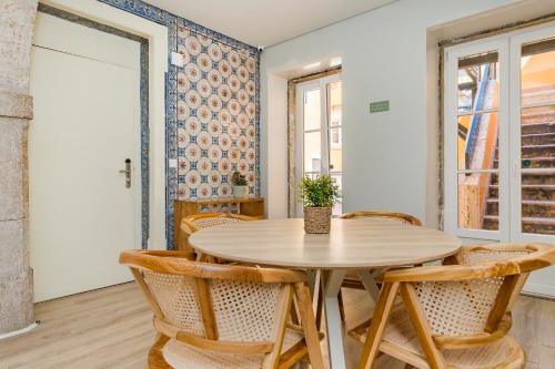 a dining room with a wooden table and chairs at Metropolitan Living Lisbon - Janelas Verdes in Lisbon