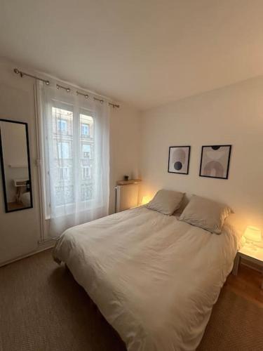 une chambre avec un lit blanc et une fenêtre dans l'établissement Situé à 7 min à pied de Paris Porte de Versailles et Métro, à Issy-les-Moulineaux