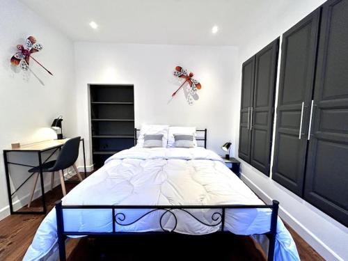 une chambre avec un grand lit et un bureau dans l'établissement Le Puyravault - Studio situé en plein centre-ville & proche des thermes, à Rochefort