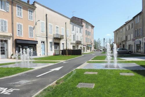 une rue avec des fontaines au milieu d'une route dans l'établissement studio cosy rénové climatisé, à Alès