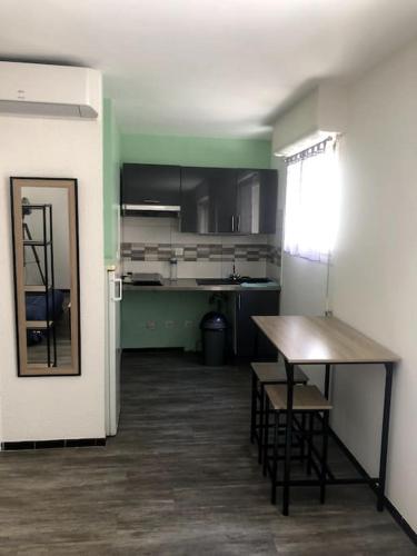 une cuisine avec une table et des chaises dans une pièce dans l'établissement studio cosy rénové climatisé, à Alès