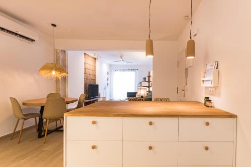 a kitchen and dining room with white cabinets and a table at K-ROOTS by Nuka Homes in Jávea