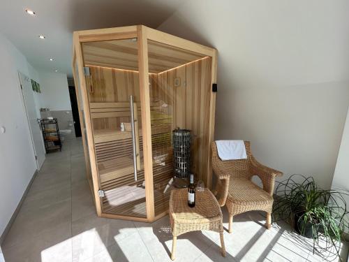 a wooden enclosure with two chairs and a table at Wellness-Ferienhaus mit Dampfbad & Sauna am Nürburgring in Leimbach