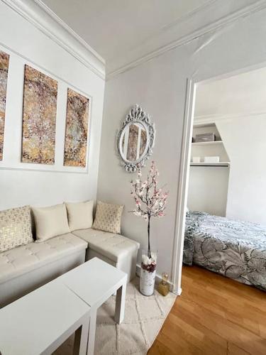 - un salon blanc avec un canapé et un lit dans l'établissement Magnifique 2p avec vue sur le sacré coeur, à Paris