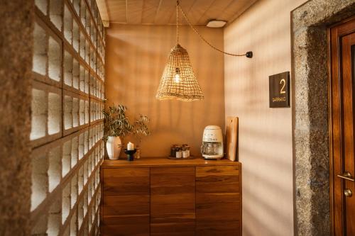 a room with a wooden cabinet and a light fixture at Vinha by NHôme in Ponte de Lima