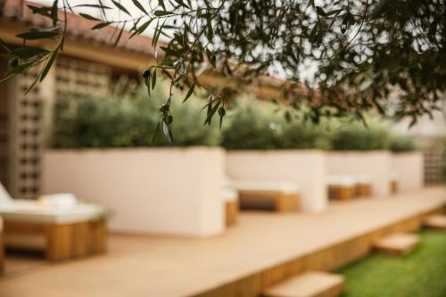 a row of benches sitting on top of a patio at Vinha by NHôme in Ponte de Lima