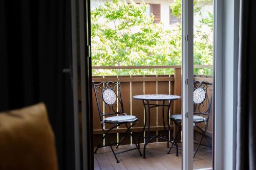 a balcony with a table and chairs and a window at Self Service Hotel Schnalser Hof in Naturno