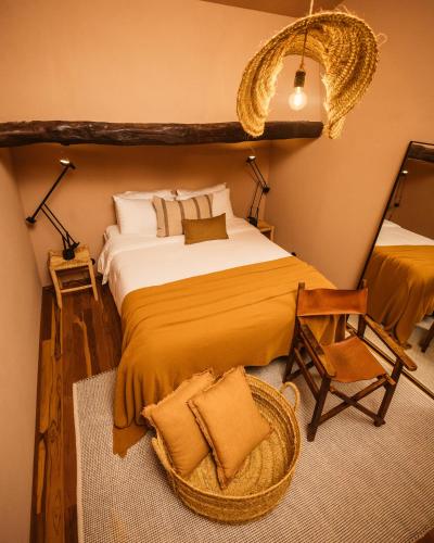 a bedroom with a large bed and a chair at Vinha by NHôme in Ponte de Lima