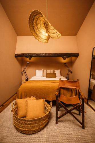 a bedroom with a bed and a table and a chair at Vinha by NHôme in Ponte de Lima