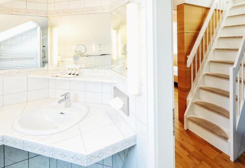 a bathroom with a sink and a staircase at Seehotel Litz in Langenargen