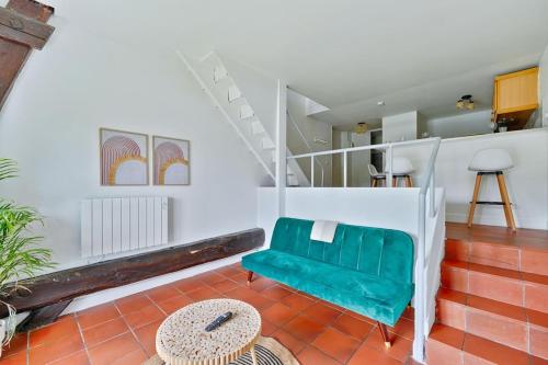 Welcome to Chic Duplex في Wissous: غرفة معيشة بها كرسي أخضر وطاولة