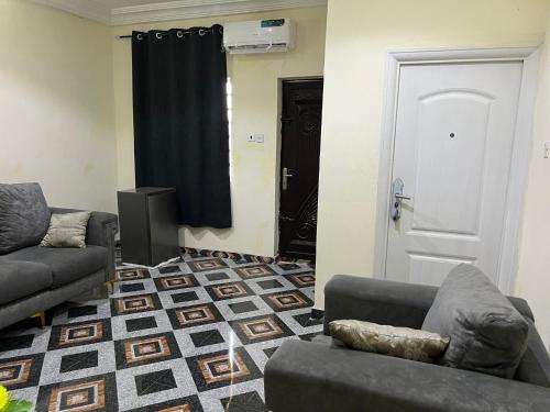 a living room with two couches and a black curtain at YP-Made Luxurious 1 & 2 Bedroom Apartments in Eluju
