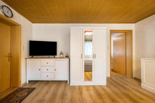 an empty living room with a television and a door at Bergmannsruh in Clausthal-Zellerfeld