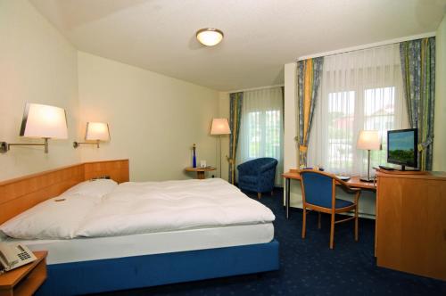 Habitación de hotel con cama y escritorio en Restaurant-Hotel Seeblick en Mörigen