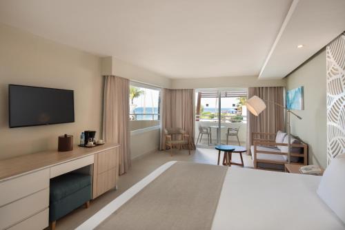a hotel room with a bed and a television at Select at Casa Marina Adults Only All Inclusive in Sosúa