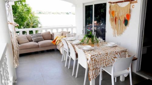 a dining room with a table and chairs and a couch at 4BlessingsCuracao2 in Willemstad