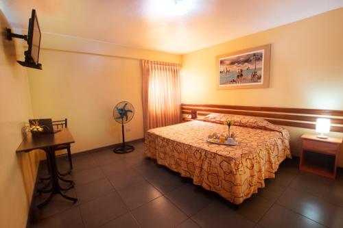 a hotel room with a bed and a table at Hotel Olaya in Lima