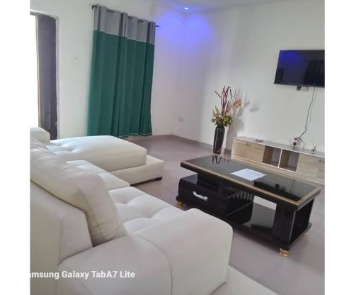a living room with a white couch and a coffee table at YP-Made Luxurious 1 & 2 Bedroom Apartments in Eluju