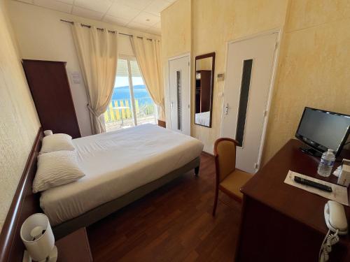 a bedroom with a bed and a desk with a computer at Le Beau Séjour in Saint-Raphaël