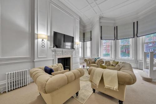a living room with couches and a television and a fireplace at Knightsbridge - Hans Place Apartments in London
