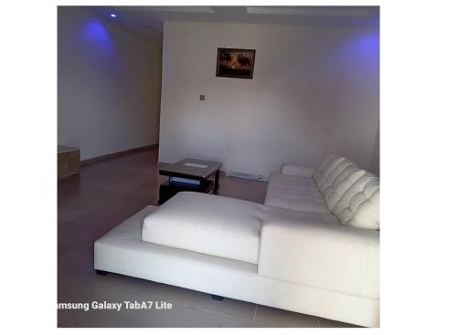 a living room with a white couch and a table at YP-Made Luxurious 1 & 2 Bedroom Apartments in Eluju