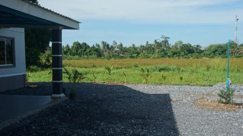 a building with a field in the background at One Lot - Lodging One in Arau