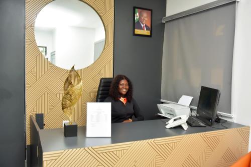 a woman sitting at a desk in an office at The Hague Maitama in Abuja