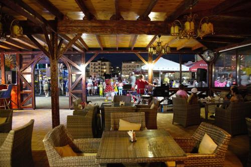 a restaurant with tables and chairs and people in the background at Hotel Imera All Inclusive in Vityazevo