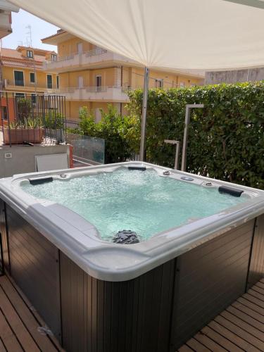 a hot tub on a deck with an umbrella at Villetta & Suite Angela Pozzallo 150mt mare v Auriga in Pozzallo