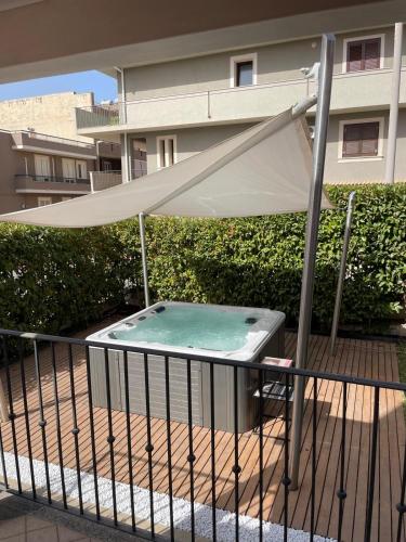 a pool with an umbrella on a balcony at Villetta & Suite Angela Pozzallo 150mt mare v Auriga in Pozzallo