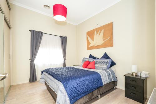 a bedroom with a bed with blue and red pillows at Brunswick Melbourne-Cosy Room-Great location in Melbourne