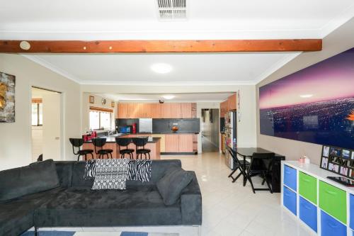 a living room with a couch and a kitchen at Brunswick Melbourne-Cosy Room-Great location in Melbourne