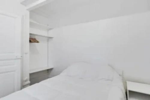 Cette chambre est dotée de murs blancs et d'une armoire blanche. dans l'établissement Charmant appartement entier à Montmartre pour 4, à Paris