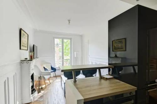 un salon avec une table et quelques chaises dans l'établissement Charmant appartement entier à Montmartre pour 4, à Paris