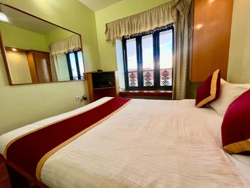 a bedroom with a large bed with a large mirror at Misty Mountain Kodaikanal in Kodaikānāl
