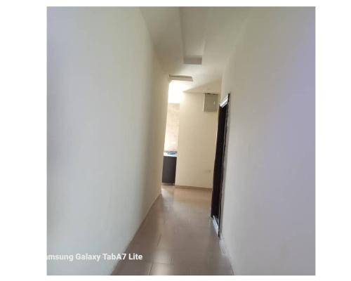 a hallway with a white wall and a black door at YP-Made Luxurious 1 & 2 Bedroom Apartments in Eluju